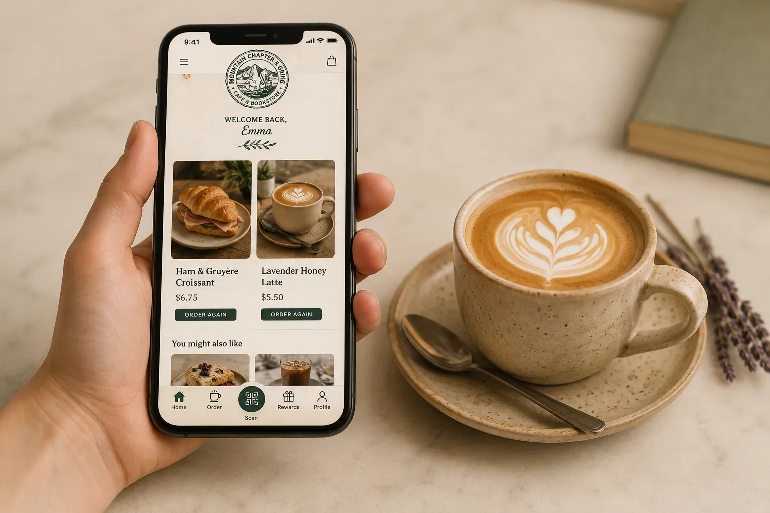 Phone in hand showing the Mountain Chapter & Grind order-ahead app beside a latte with heart rosetta.